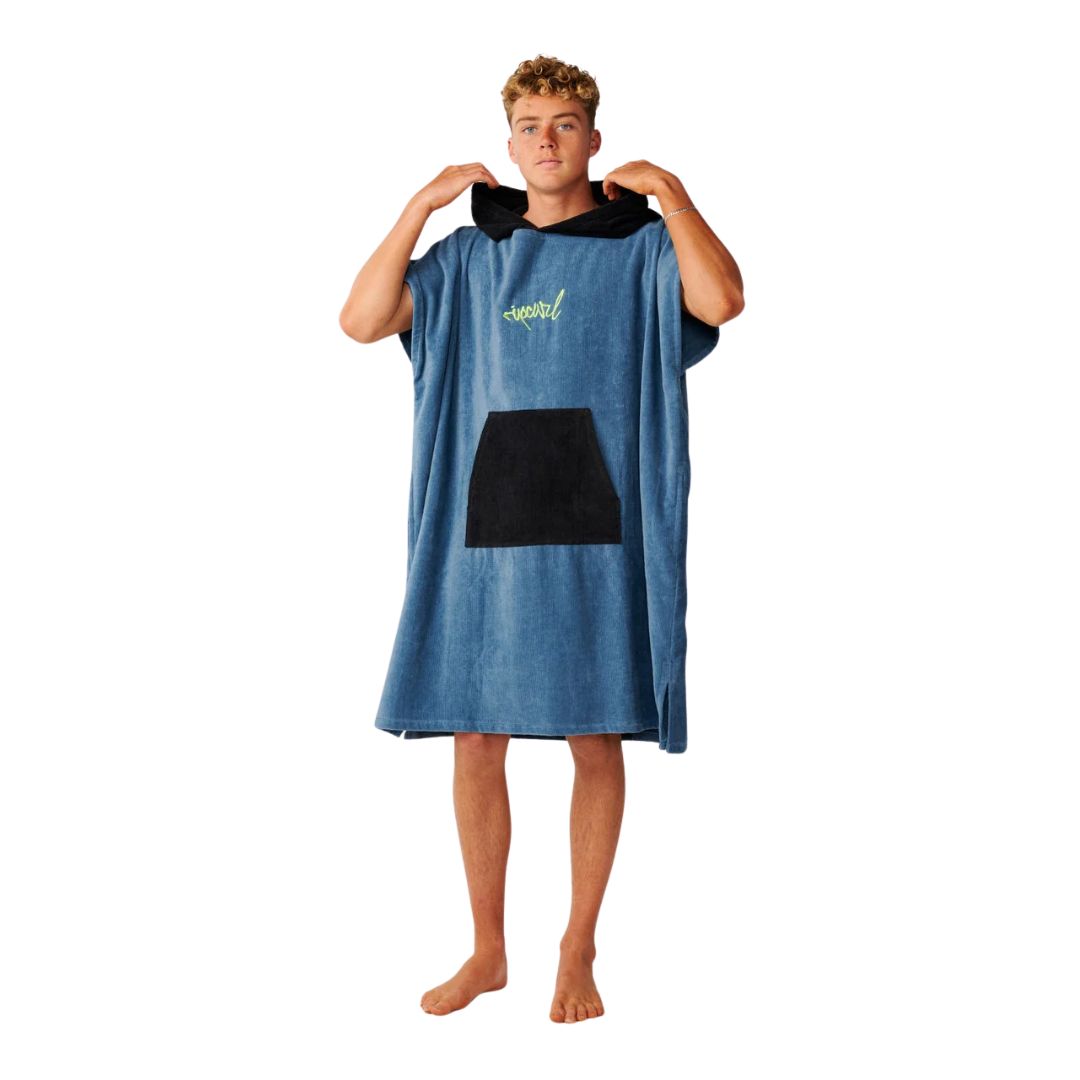 Poncho toalla con capucha Rip Curl Bluefin de frente, modelo colocándose la capucha, con el logo bordado en verde flúor visible en el pecho.