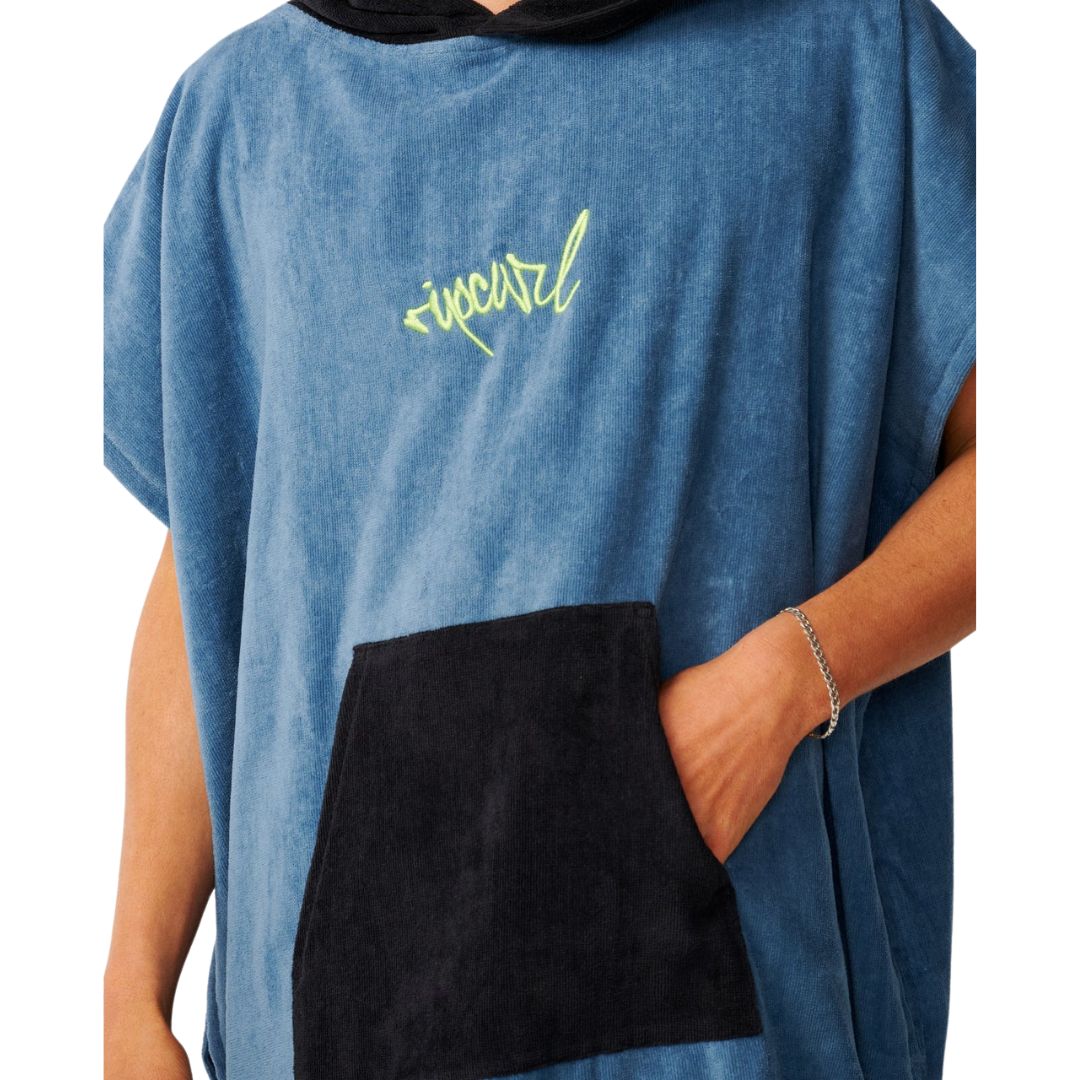 Detalle del poncho toalla Rip Curl Bluefin: logo bordado ripcurl en verde flúor y bolsillo canguro negro en primer plano.