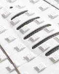 Detalle de los cortes estratégicos LOC-LITE negros en el patrón Square Loc blanco del grip de surf Creatures Mick Fanning Signature white black para máximo contacto del pie.