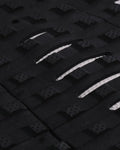 Detalle de los cortes estratégicos LOC-LITE blancos en el patrón Square Loc negro del grip de surf Creatures Mick Fanning Signature black white para máximo contacto del pie.