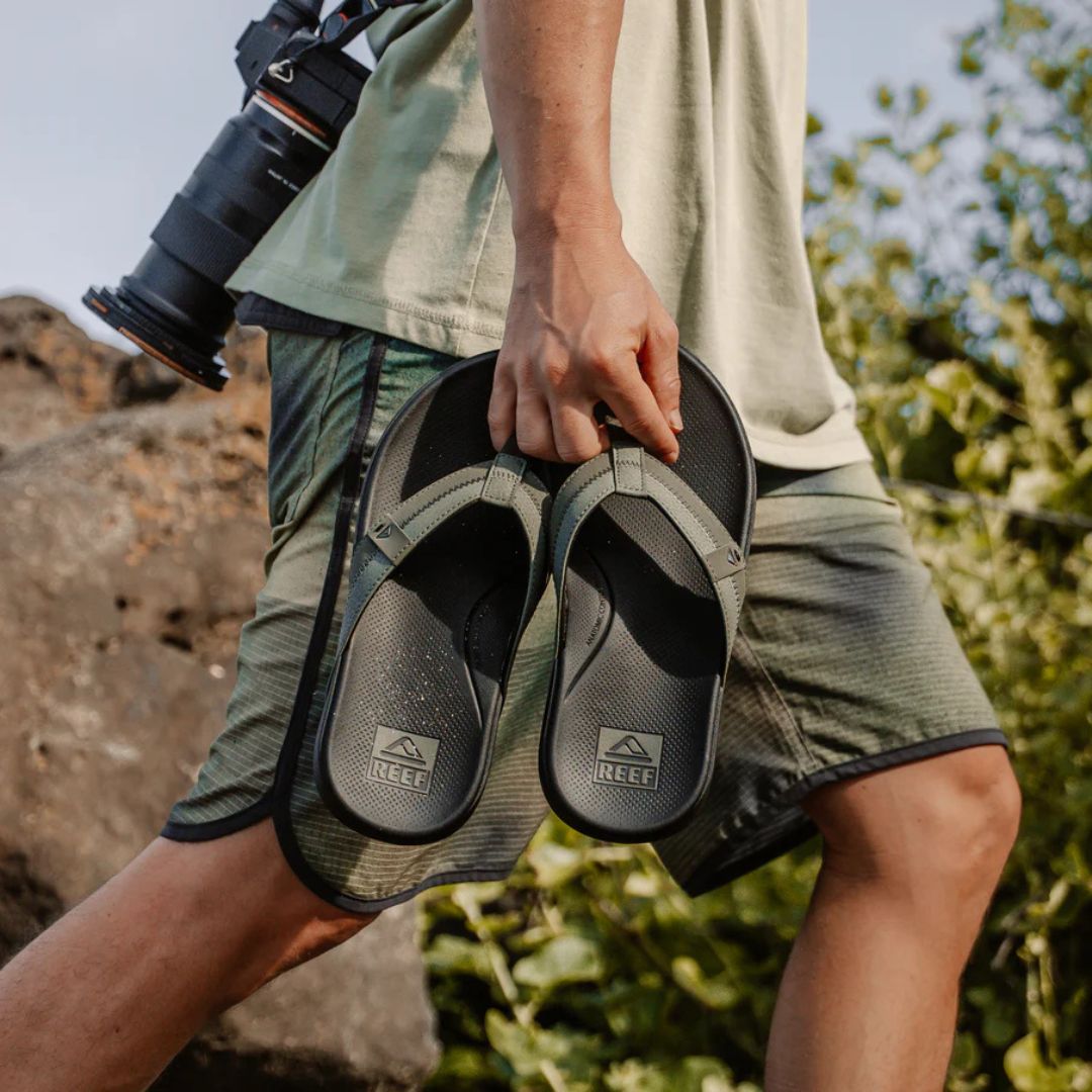 Chanclas Reef Cushion Phantom 2.0 olive gum en mano con tira verde oliva acolchada y plantilla ergonómica negra de alta amortiguación.