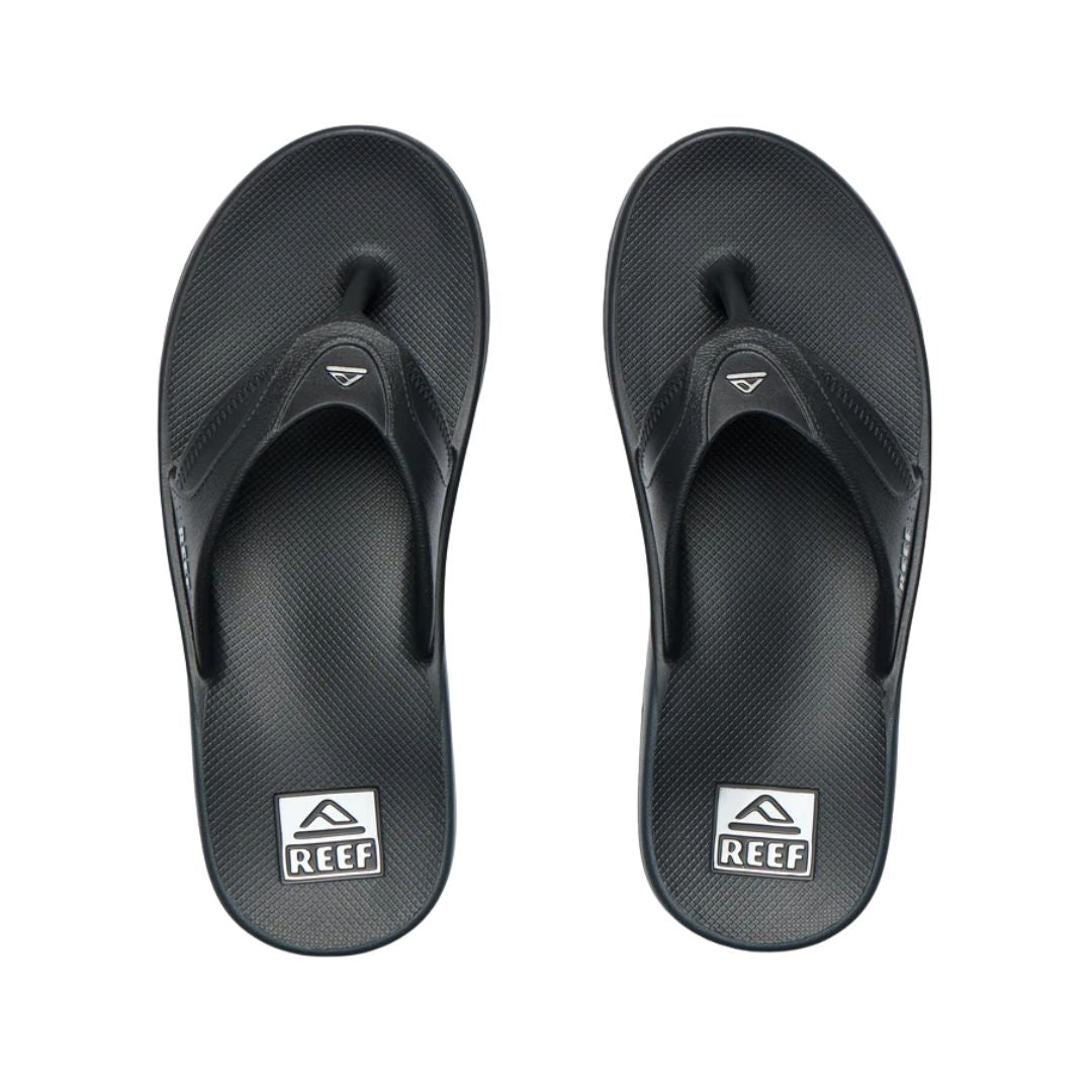 Vista superior chanclas Reef Fanning H2O negro con logo plateado y plantilla ergonómica antideslizante.
