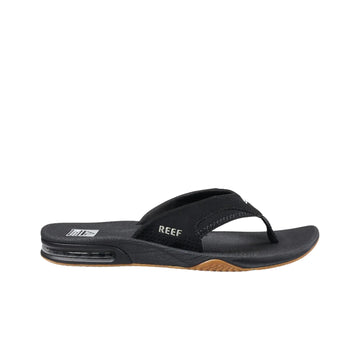 Vista lateral de las chanclas REEF Fanning en color negro con suela marrón, diseño cómodo y deportivo para hombre.