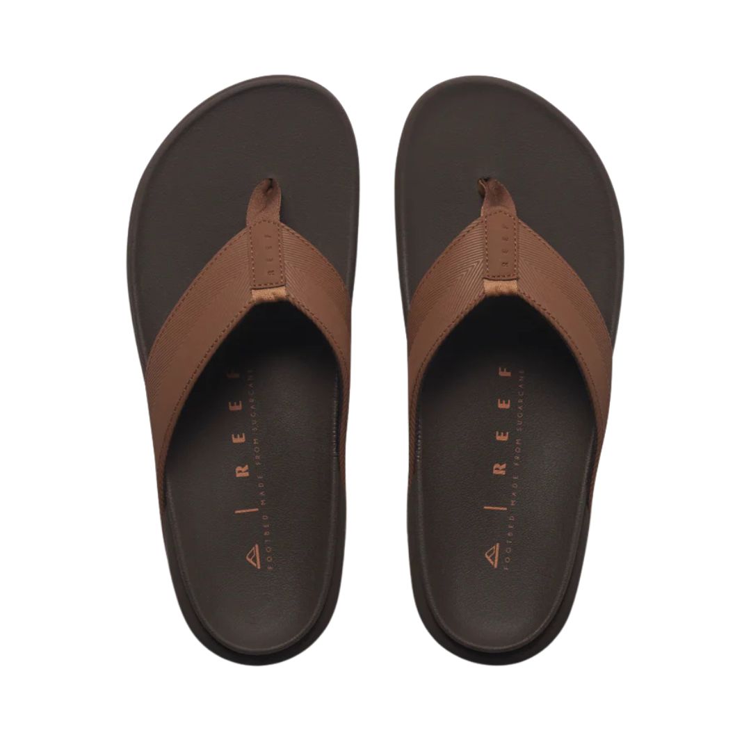 Vista superior chanclas Reef The Raglan color marrón java con tira acolchada y footbed anatómico cómodo.