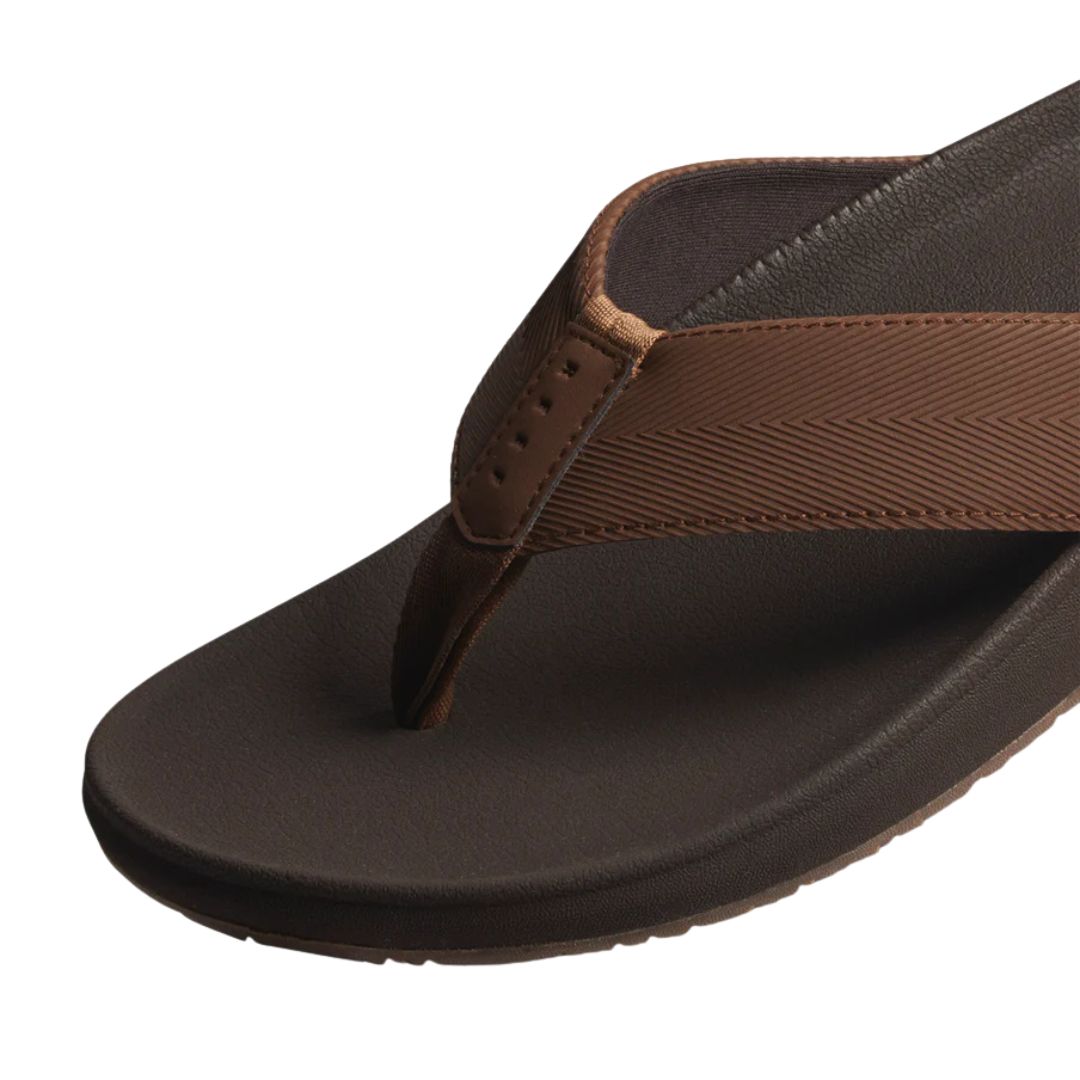 Detalle tira chanclas Reef The Raglan marrón java con acabado texturizado y acolchado interior suave.
