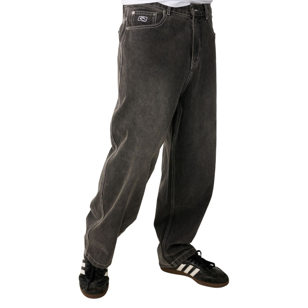 Detalle de la cintura y pernera lateral del Rip Curl Archive Dirty Denim Pant en Washed Grey, mostrando el lavado sucio y las costuras de contraste.