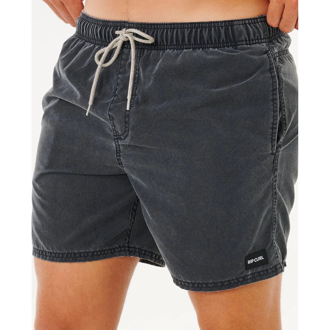 Detalle frontal del bañador Rip Curl Offset Washed Volley 16" negro con lavado enzimático, costuras decorativas en el bajo y etiqueta tejida Rip Curl.