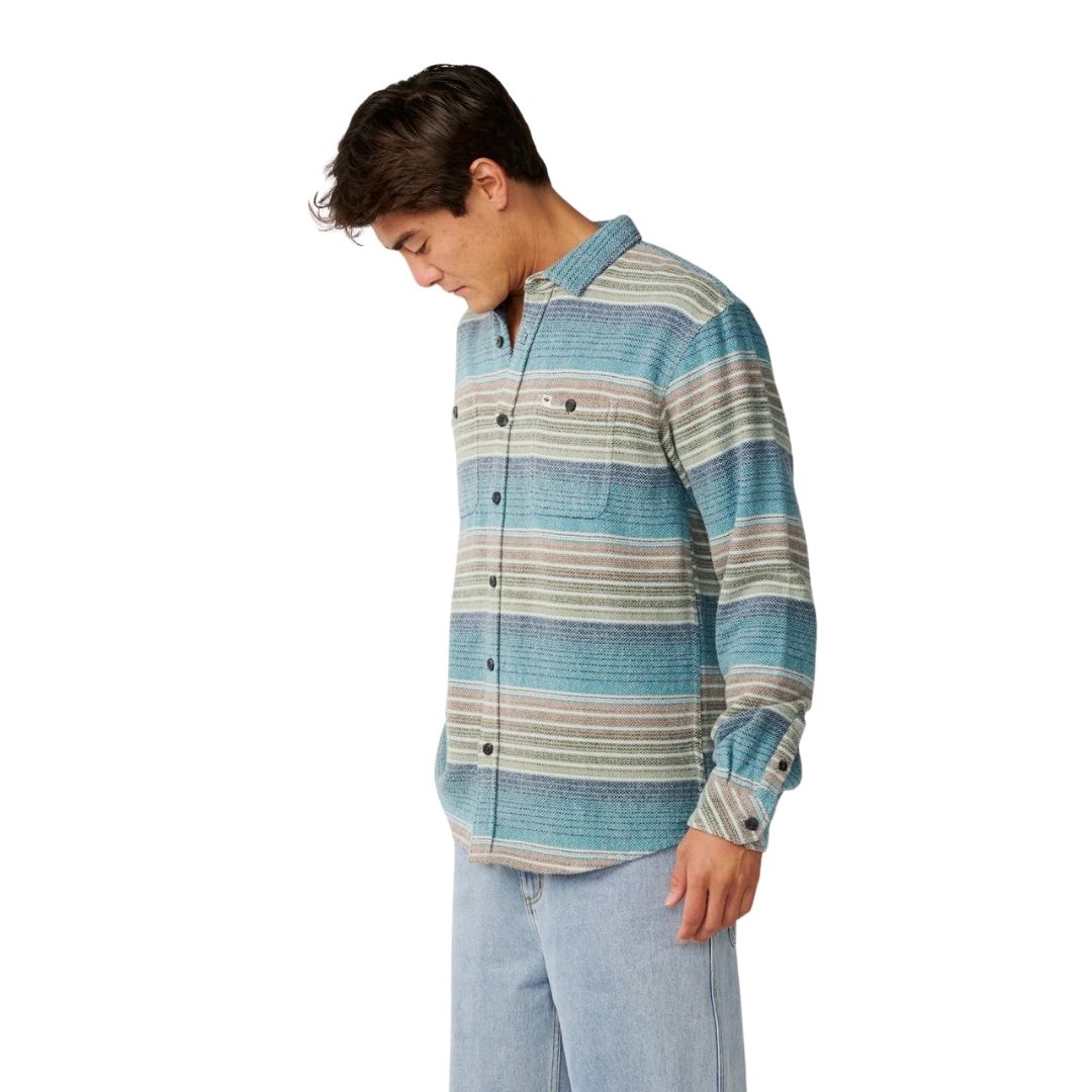 Vista de perfil de la camisa Rip Curl Classic Surf Baja Flannel Dusty Jade con corte amplio, mangas largas y puño abotonado, luciendo el degradado de rayas jaspeadas en tonos costeros.