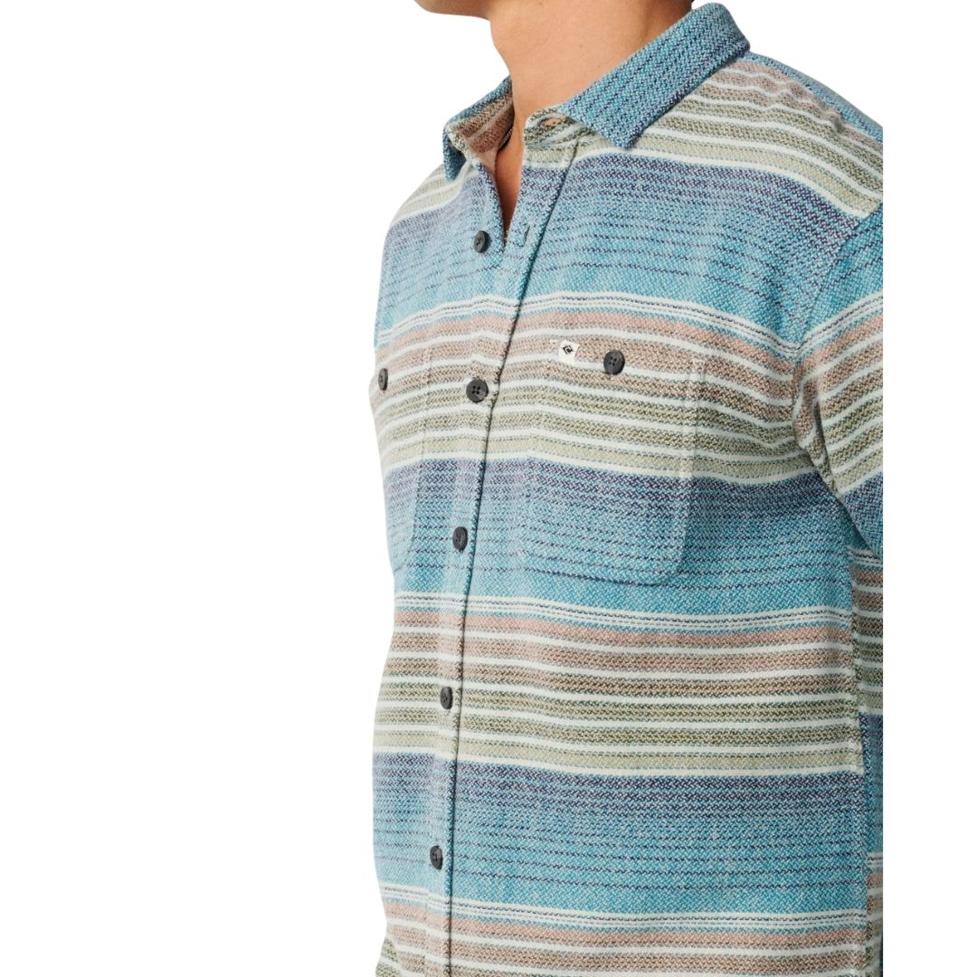 Primer plano de la camisa Rip Curl Classic Surf Baja Flannel Dusty Jade mostrando el bolsillo de parche con etiqueta tejida, botonadura oscura tipo cuerno y el tejido jaspeado de rayas teñidas en masa