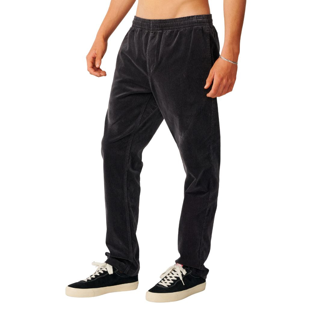 Rip Curl Classic Surf Cord Beach Pant en Washed Black, vista lateral de tres cuartos, mostrando la caída relajada del pantalón de pana.