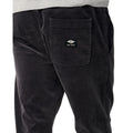 Detalle del bolsillo trasero con solapa del Rip Curl Classic Surf Cord Beach Pant en Washed Black, con la etiqueta tejida Rip Curl y el acabado en pana.