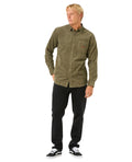 Hombre con la camisa de pana Rip Curl Classic Surf Cord Shirt Verde Oliva y vaqueros negros