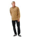 Hombre con la camisa de pana Rip Curl Classic Surf Cord Shirt Caqui oscuro y vaqueros negros