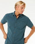 Modelo luciendo la camisa Rip Curl Classic Surf Washed con pantalones oscuros, ideal para un look surfero y casual.