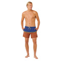 Bañador surf Rip Curl Combine Volley baked clay, vista frontal completa con color block azul marino y terracota, rayas doradas bordadas y volley fit 16 pulgadas.