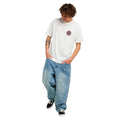 Camiseta Rip Curl Destroy Series color Bone combinada con vaquero ancho, look completo de cuerpo entero mostrando el corte Relaxed Fit y el estampado frontal.