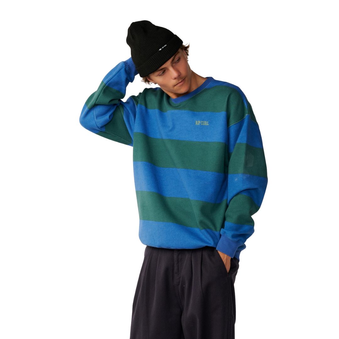 Rip Curl Disorder Stripe Crew en Riverside, vista frontal con el modelo ajustándose el gorro, mostrando el logo Rip Curl bordado en el pecho.