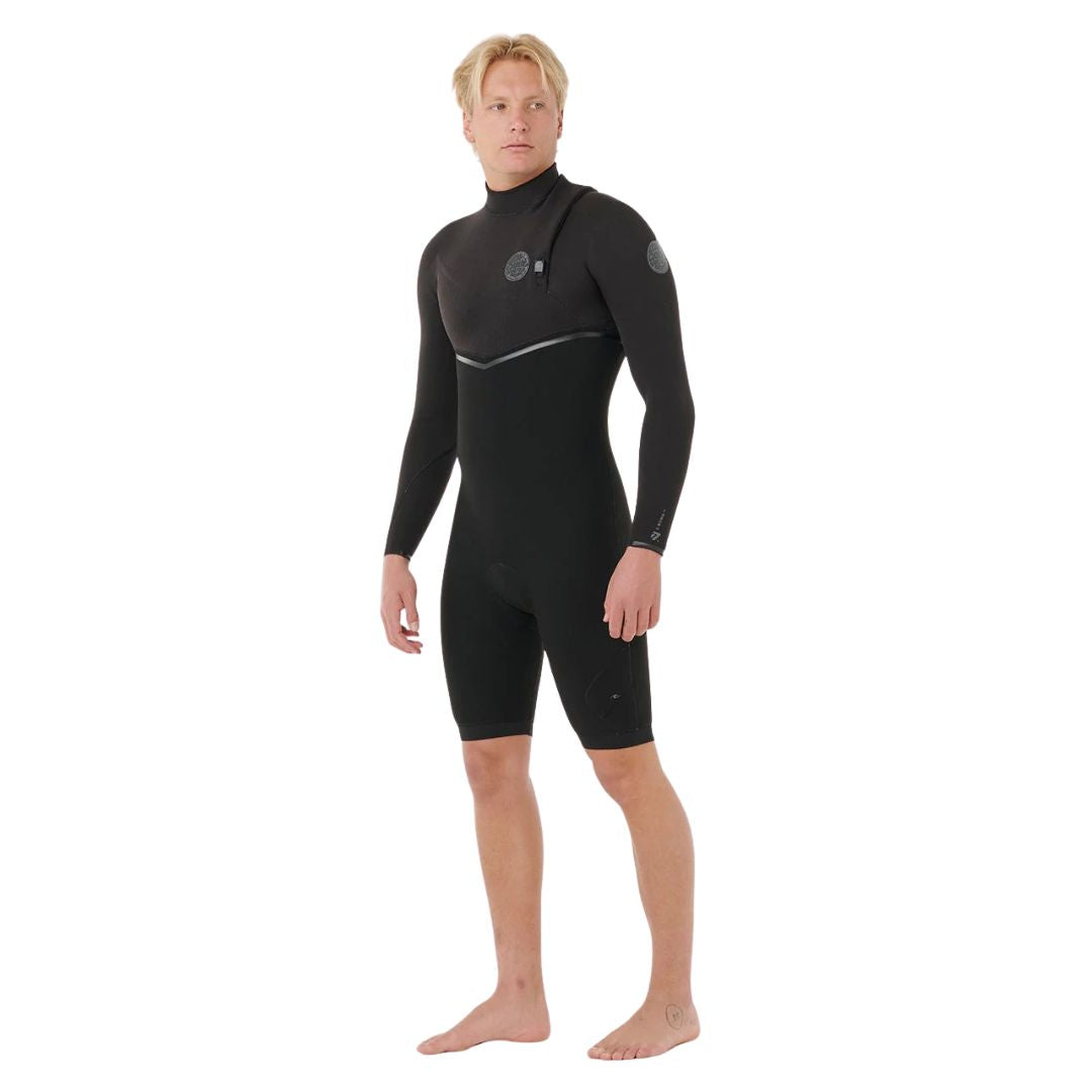Traje de primavera Rip Curl E-Bomb 2/2mm Zip Free negro, vista lateral en tres cuartos: manga larga, pierna corta, logos en pecho y manga, cierre Zip Free y línea en V en cintura.