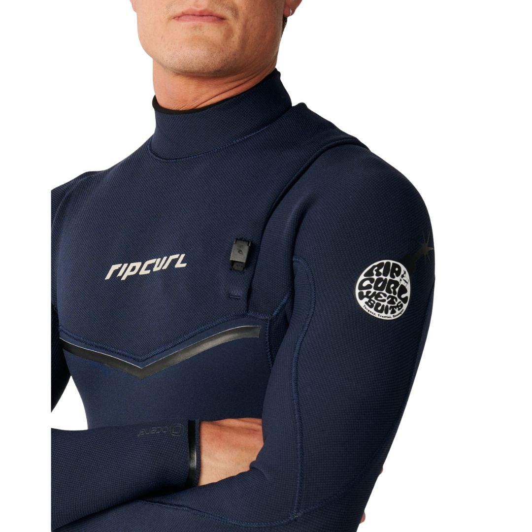 Traje de neopreno RIP CURL E-BOMB ZIP FREE 4/3 en Navy, primer plano del pecho y hombro con el logotipo RIP CURL, el cierre de entrada y el parche circular RIP CURL WETSUITS en la manga.