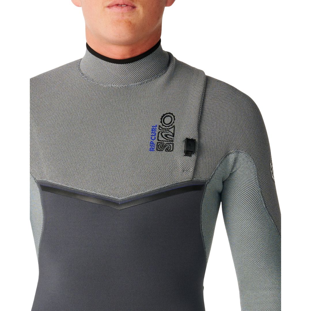 Traje de neopreno RIP CURL E-BOMB ZIP FREE 4/3 en Charcoal Grey, plano medio en ángulo con el parche circular RIP CURL WETSUITS en la manga y el contraste entre el gris claro y el gris antracita.