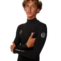 Detalle del sistema de entrada sin cremallera del Rip Curl Elasto Zip Free 5/4 en negro, con panel de pecho, logos Rip Curl Wetsuits y texto Elasto en el puño.