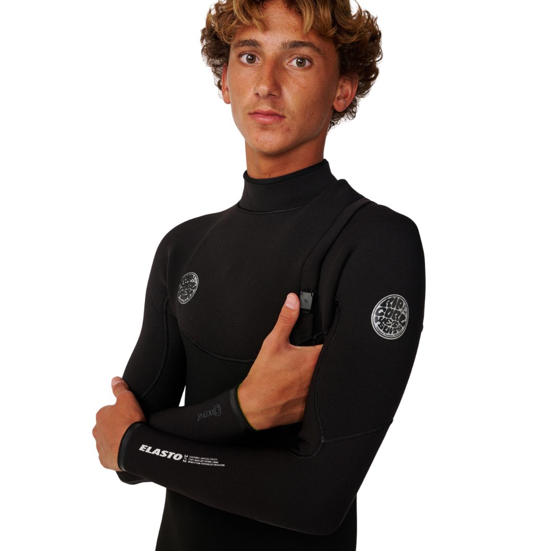 Detalle del sistema de entrada sin cremallera del Rip Curl Elasto Zip Free 5/4 en negro, con panel de pecho, logos Rip Curl Wetsuits y texto Elasto en el puño.