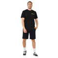 Camiseta negra Rip Curl EWG Comp Tee completa en look masculino con bermudas, vista frontal.