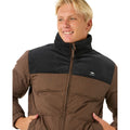 Chaqueta Rip Curl Fade Out Cord Puffer para hombre en marrón y negro, vista frontal con cremallera cerrada.