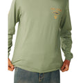 Detalle del pecho de la camiseta manga larga Rip Curl Fade Out Icon color sage, con el gráfico Rip Curl Born at Bells 1969.