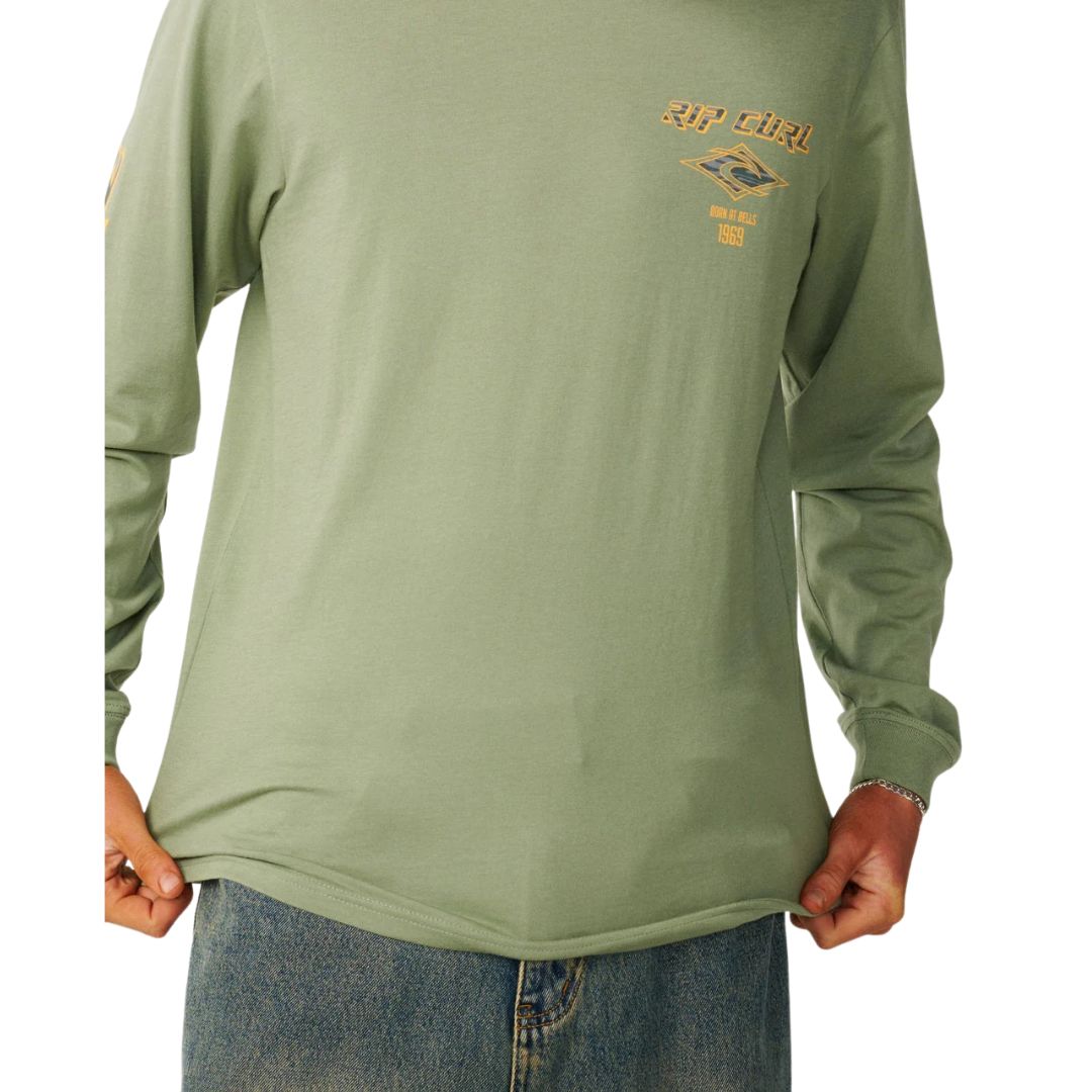 Detalle del pecho de la camiseta manga larga Rip Curl Fade Out Icon color sage, con el gráfico Rip Curl Born at Bells 1969.