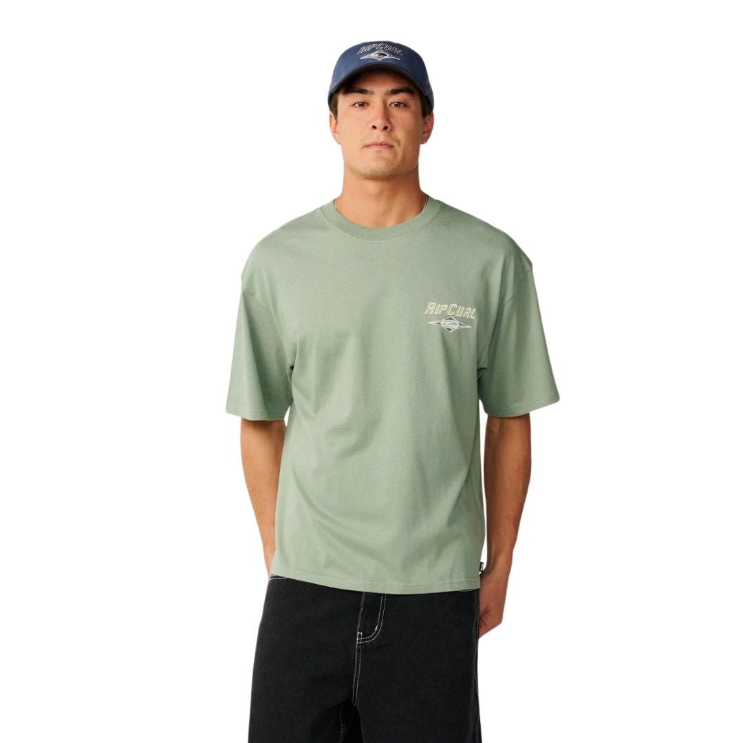 Camiseta Rip Curl Fade Out Icon Tee hombre color sage, corte oversized, logo Rip Curl pequeño en pecho izquierdo, gorra a juego, vista frontal.