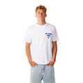 Camiseta Rip Curl Fade Out Icon Tee hombre color blanco, vista frontal, logo Rip Curl azul en pecho, combinada con vaquero ancho.