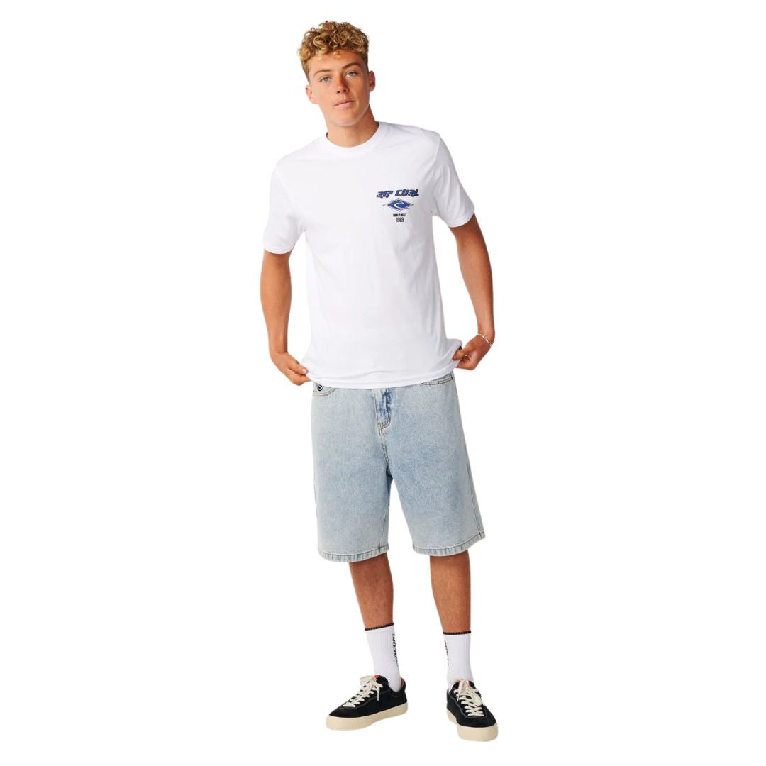 Camiseta Rip Curl Fade Out Icon Tee hombre color blanco, cuerpo entero, combinada con bermuda vaquera clara y zapatillas Rip Curl.