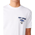 Detalle del logo Rip Curl azul con diamante y texto Born at Bells 1969 estampado en el pecho de la camiseta Fade Out Icon Tee blanca.