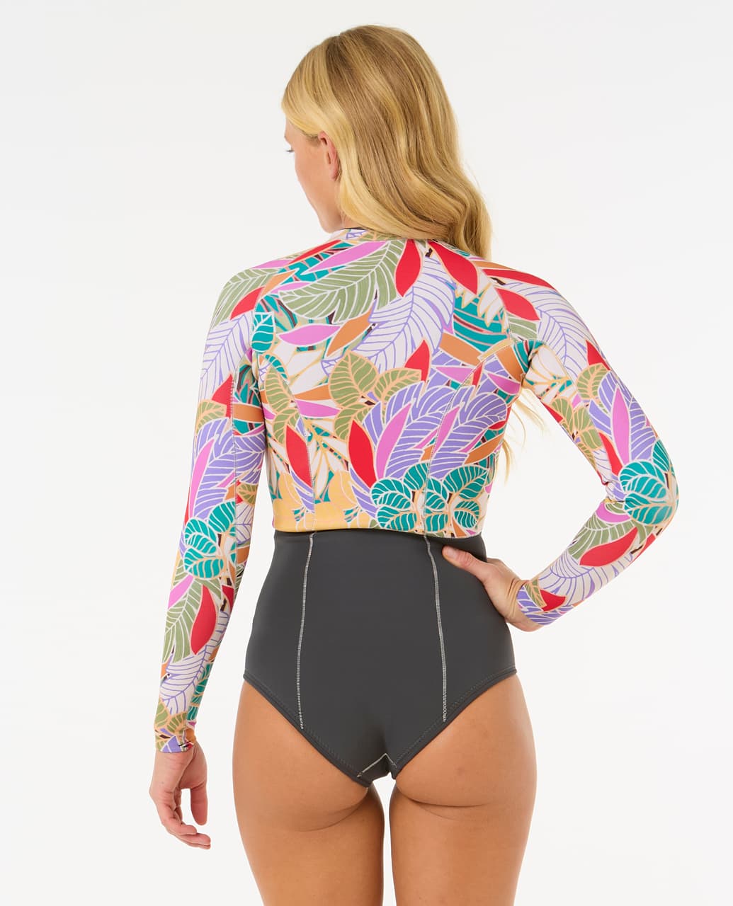 Mujer de cuerpo entero con traje de neopreno RIP CURL G-BOMB 1.5MM FZ SPRINGSUIT, en pose natural sobre fondo blanco.