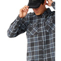 Primer plano del bolsillo de pecho y la botonadura de la Rip Curl Griffin Flannel en Washed Black, mostrando de cerca el estampado de cuadros en azul y gris.