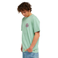 Camiseta de surf RIP CURL HARDCORE TEE SERIES en Aloe, vista frontal en ángulo mostrando el logotipo circular en el pecho y el ajuste relajado del tejido de algodón.