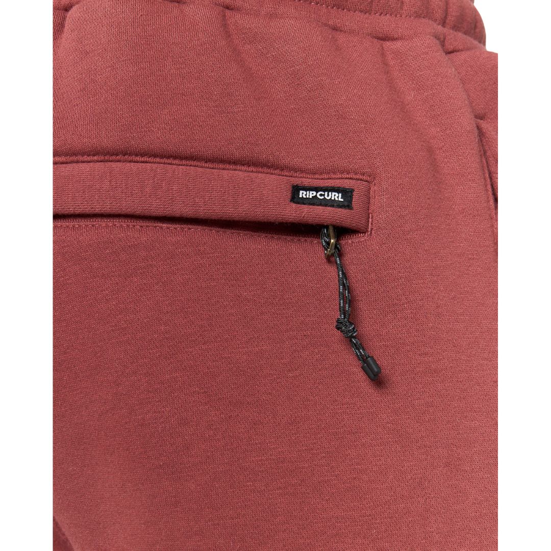 Detalle del bolsillo trasero del pantalón Rip Curl Icons of Surf color Apple Butter, con etiqueta de marca y cordón elástico.