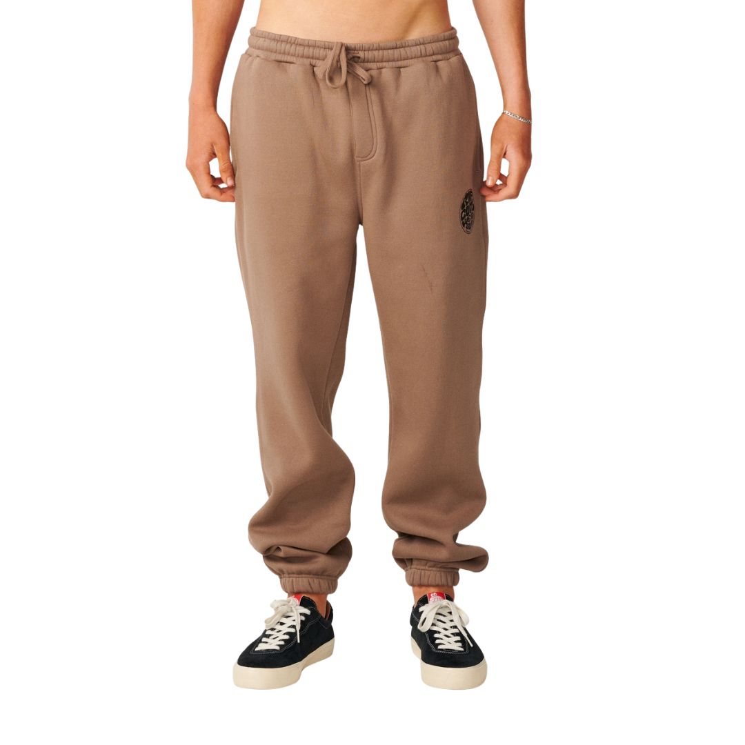 Pantalón jogger Rip Curl Icons of Surf Trackpant en Walnut, vista frontal con cordón de cintura ajustado y sello Rip Curl Wetsuits en la pierna izquierda.