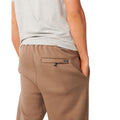 Detalle del bolsillo trasero con cremallera del Rip Curl Icons of Surf Trackpant en Walnut, con la etiqueta tejida Rip Curl junto al cierre.