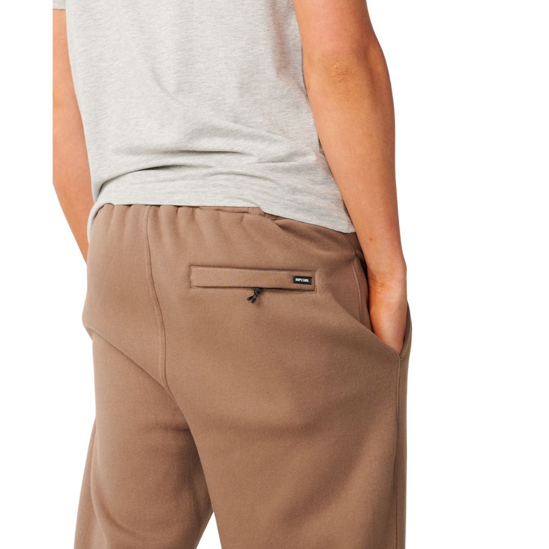Detalle del bolsillo trasero con cremallera del Rip Curl Icons of Surf Trackpant en Walnut, con la etiqueta tejida Rip Curl junto al cierre.