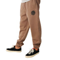 Detalle del sello circular Rip Curl Wetsuits estampado en la pierna izquierda del Rip Curl Icons of Surf Trackpant en Walnut.