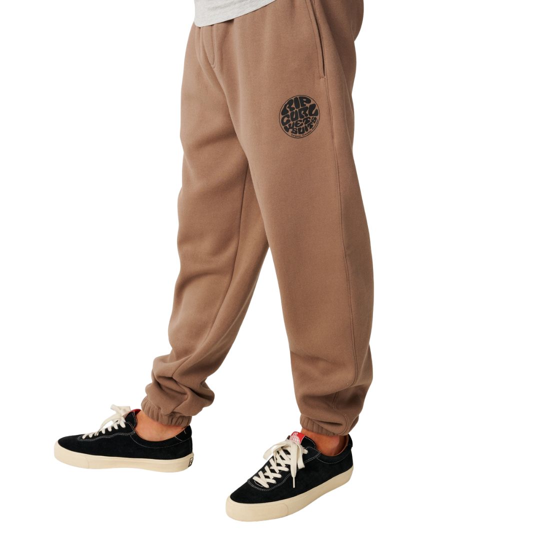 Detalle del sello circular Rip Curl Wetsuits estampado en la pierna izquierda del Rip Curl Icons of Surf Trackpant en Walnut.