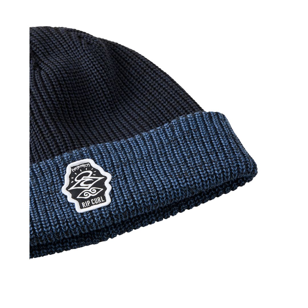 Detalle de la vuelta azul marino del gorro RIP CURL Icons Reg con parche tejido.