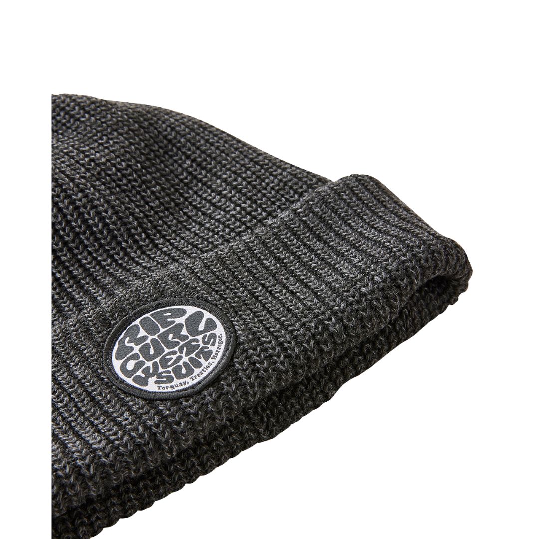 Primer plano del tejido del gorro RIP CURL Icons Reg negro con distintivo redondo.