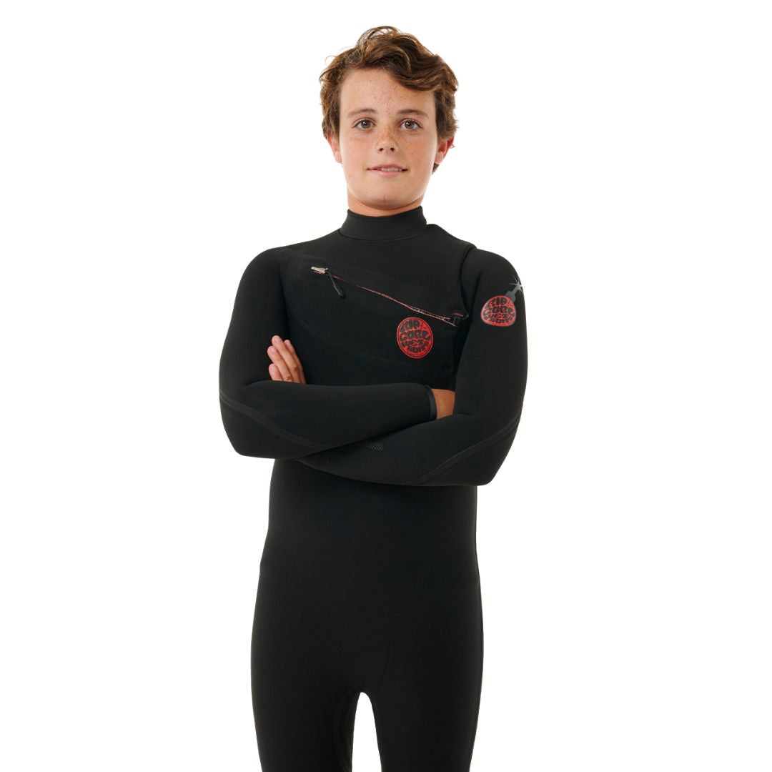 Niño con traje Rip Curl Kids F-Bomb Fusion 4/3mm negro posando con brazos cruzados, vista frontal.