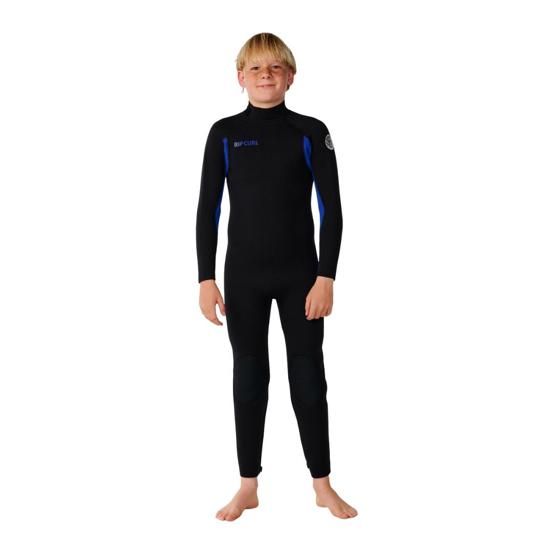 Rip Curl Kids Trad Back Zip 4/3 en color azul, traje de neopreno infantil visto de frente completo, con logo bordado en pecho y parche circular en hombro sobre la costura azul.
