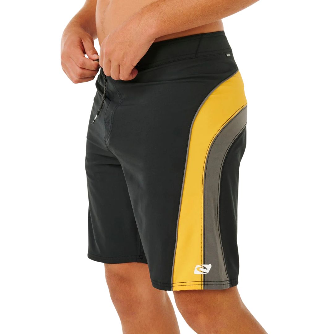 Bañador surf Rip Curl Mirage Archive amarillo y negro, vista lateral con bolsillo oculto cremallera, panel cut-and-sew amarillo con piping gris y logo heat transfer.