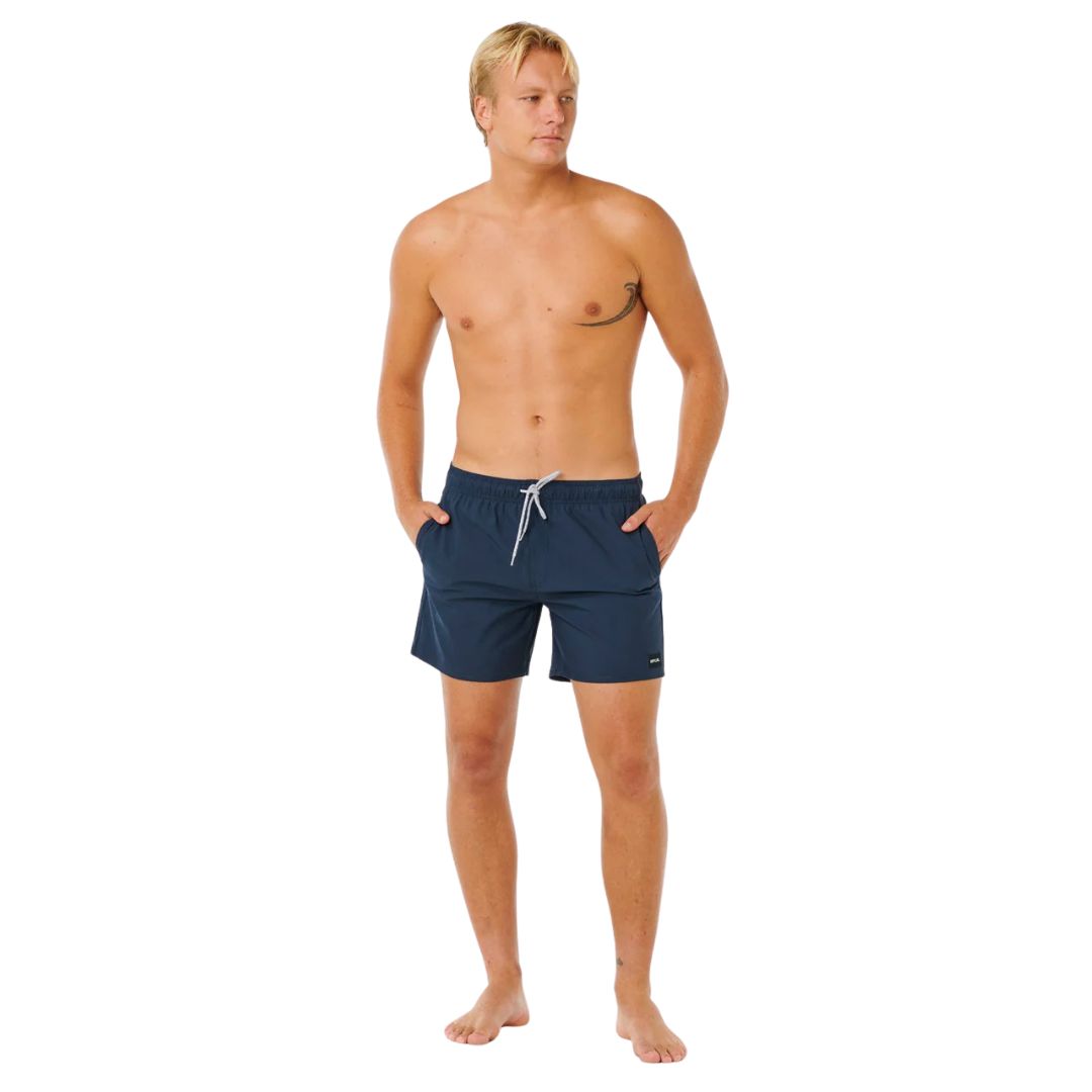 Hombre con bañador Rip Curl Offset Daily Volley 16" azul marino, vista completa frontal con corte volley fit, cordón blanco y bolsillos laterales.