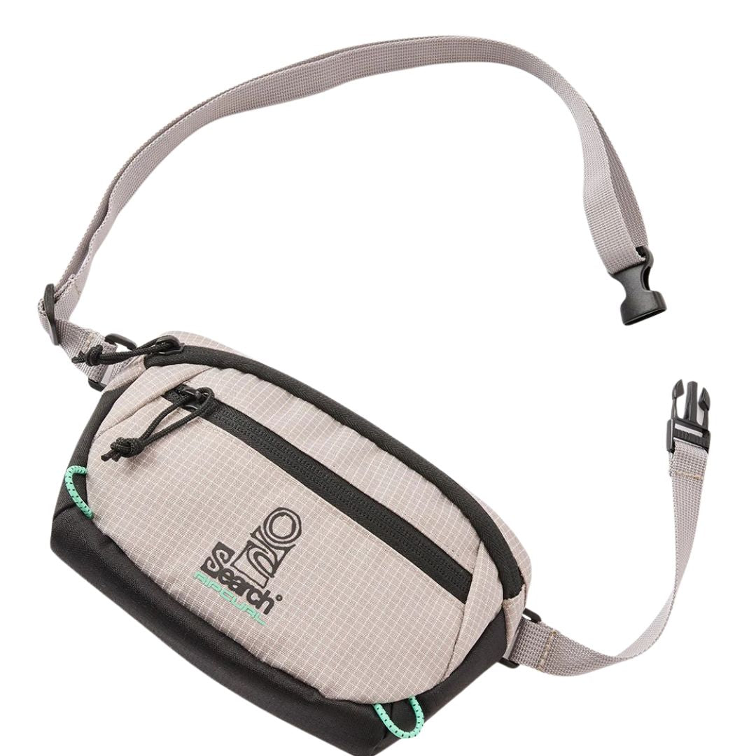 Rip Curl Overland Waist Bag Search riñonera compacta color stone con bolsillo frontal y tiradores verdes vista frontal.